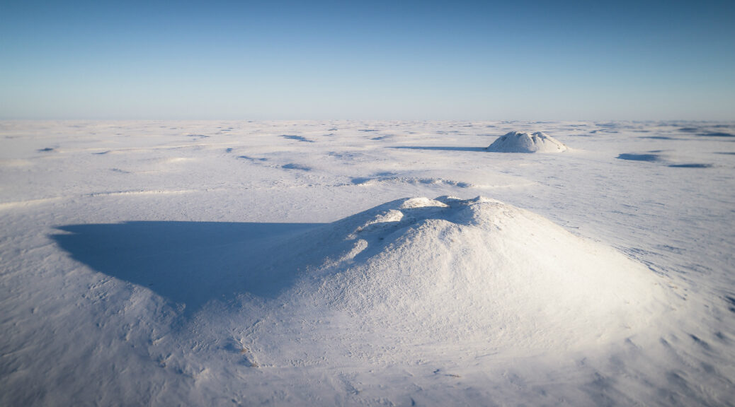 Ice-cored pingos emerge from permafrost and dot the arctic landscape near Tuktoyaktuk. Photo Credit: https://montecristomagazine.com/travel/northern-canada-ice-road